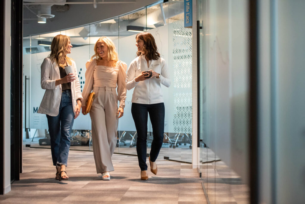 Three business and IT consultants walk through one of Turnberry's modern offices