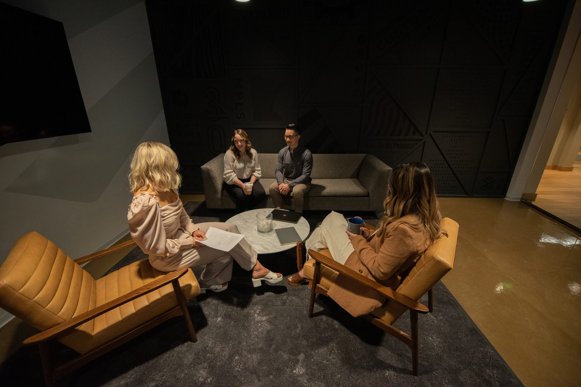 Four Turnberry employees meet in a casual, private meeting space at Turnberry's modern offices