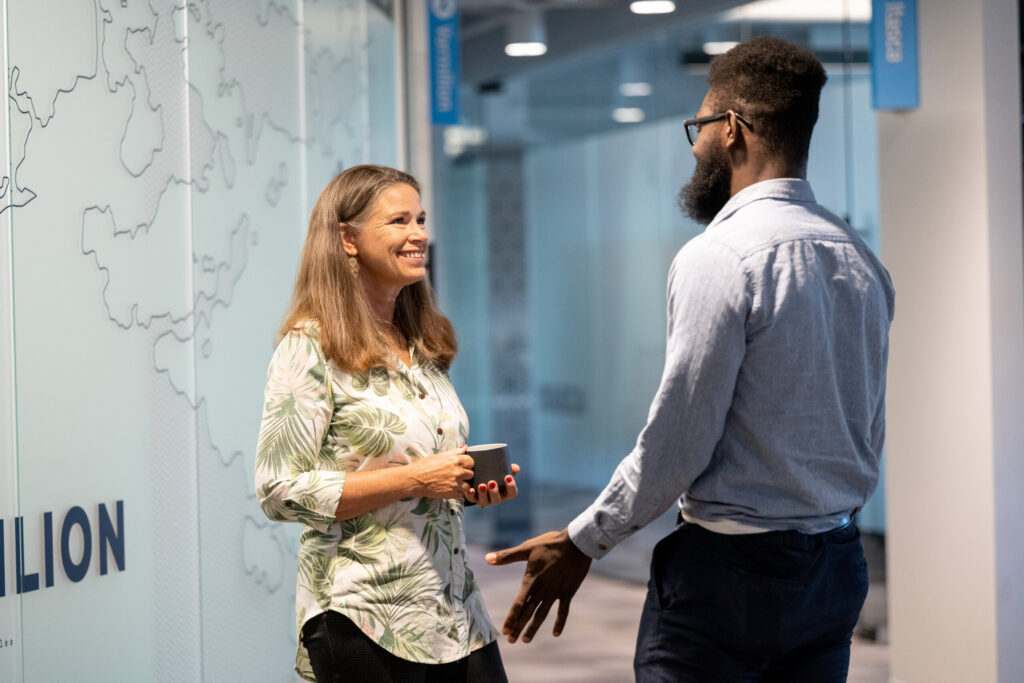 Two colleagues converse in a hallway at Turnberry's modern offices in Minneapolis