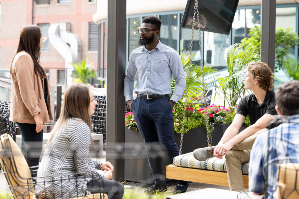 Five Turnberry professionals converse on Turnberry's rooftop terrace space in downtown Minneapolis