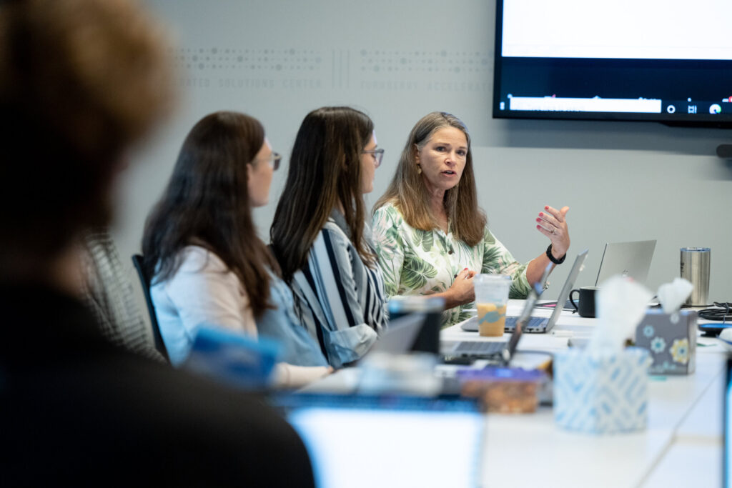 A mature female Turnberry professional adds to the conversation about Women in STEM during a presentation at Turnberry's modern offices in Minneapolis, Minnesota