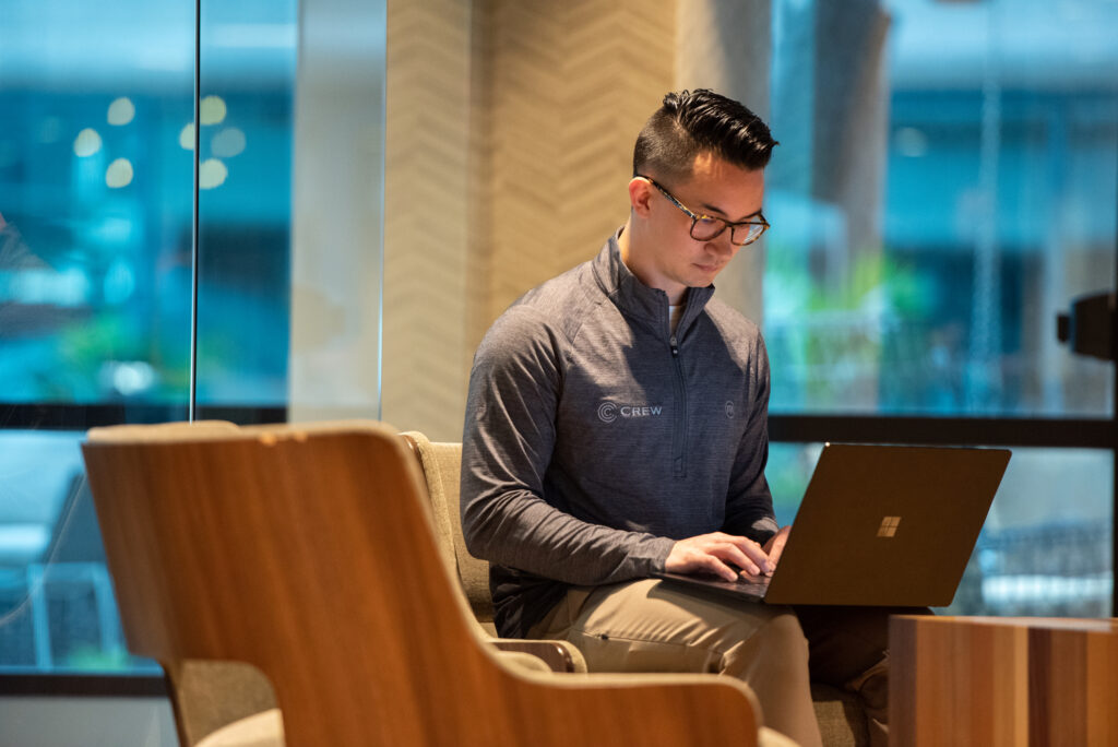 A male Turnberry crew member types on a laptop in Turnberry's modern Minneapolis office