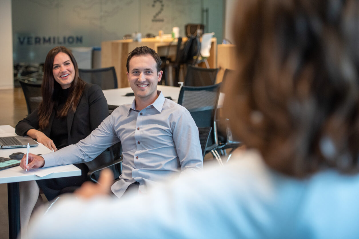 Two Turnberry Crew professionals listen to a speaker at Turnberry's modern offices in Minneapolis