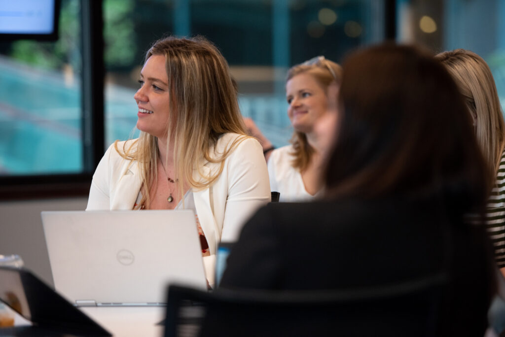 Female professionals at Turnberry listen to speaker at Minneapolis offices