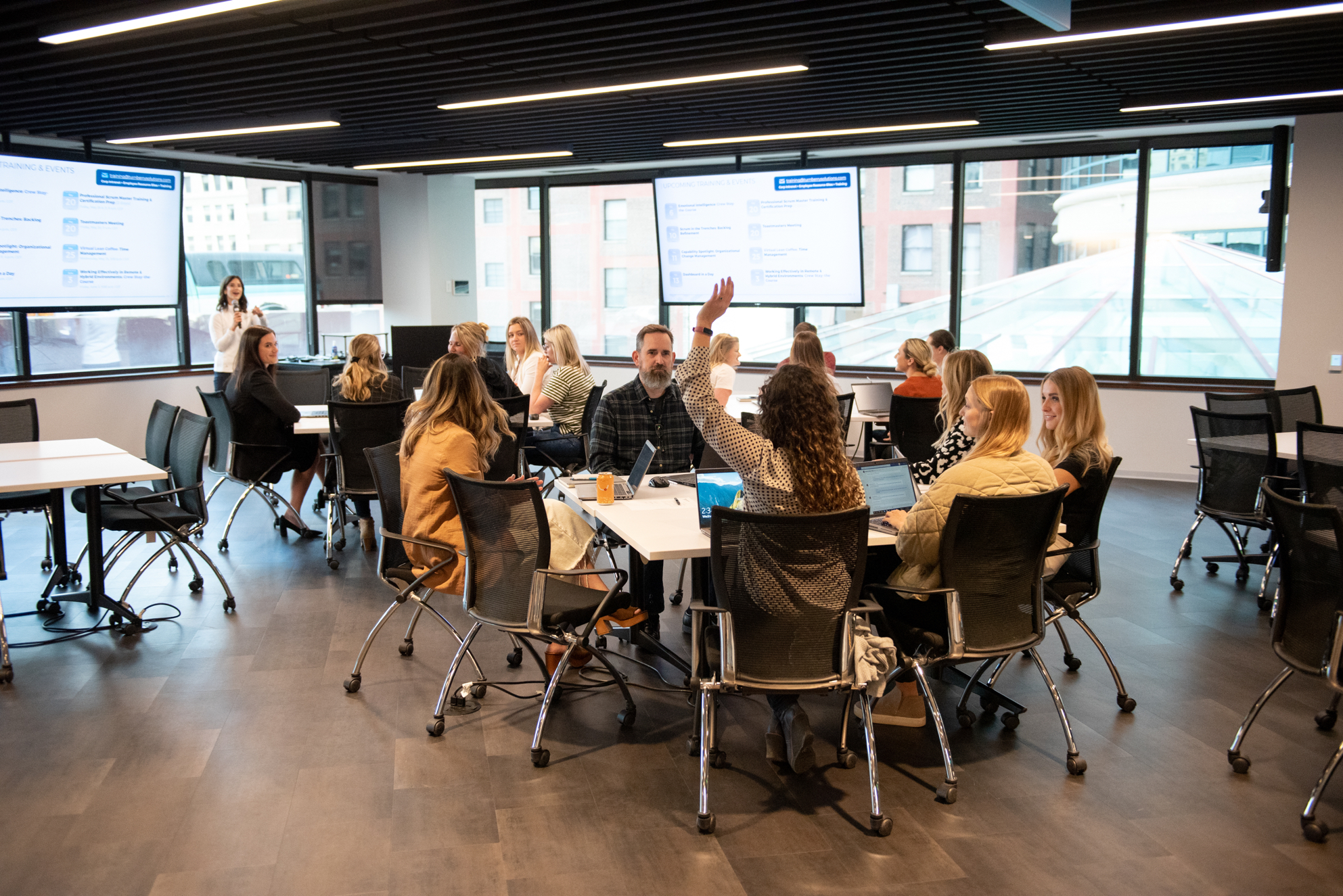 Three tables of Turnberry professionals meet to participate in a presentation at Turnberry's modern offices in Minneapolis, Minnesota