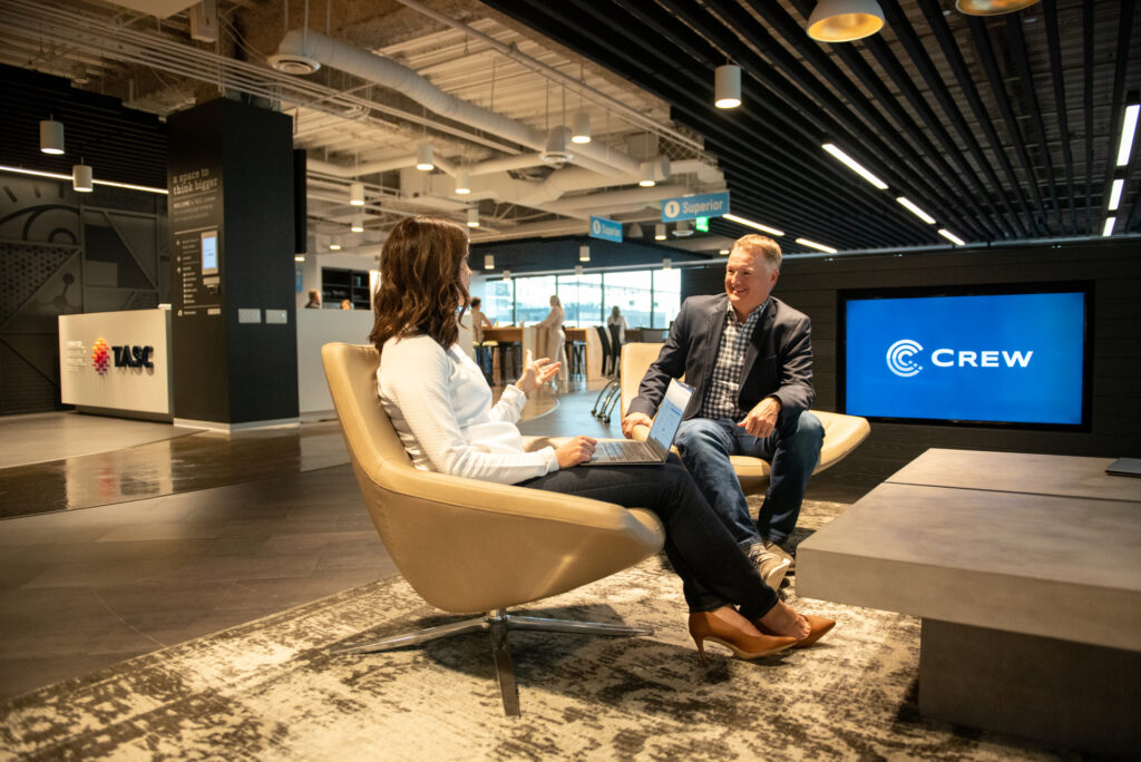 A mid-career professional woman converses with a mature male colleague at Turnberry's modern offices in Minneapolis