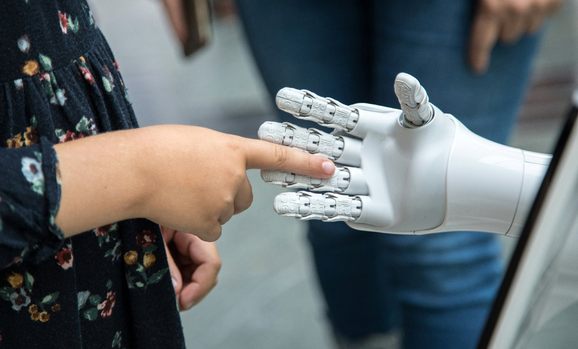 Human hand touching a robotic hand, symbolizing AI-human collaboration