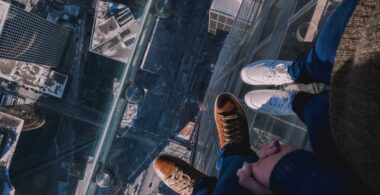 Two people hold hands while standing on the Skydeck at Willis Tower, Chicago to convey why transparency is so scary